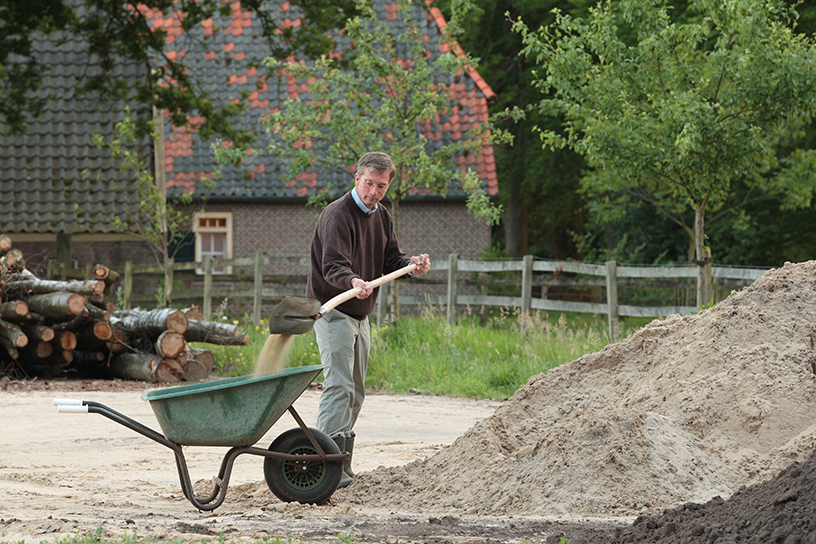 Zand scheppen in een kruiwagen